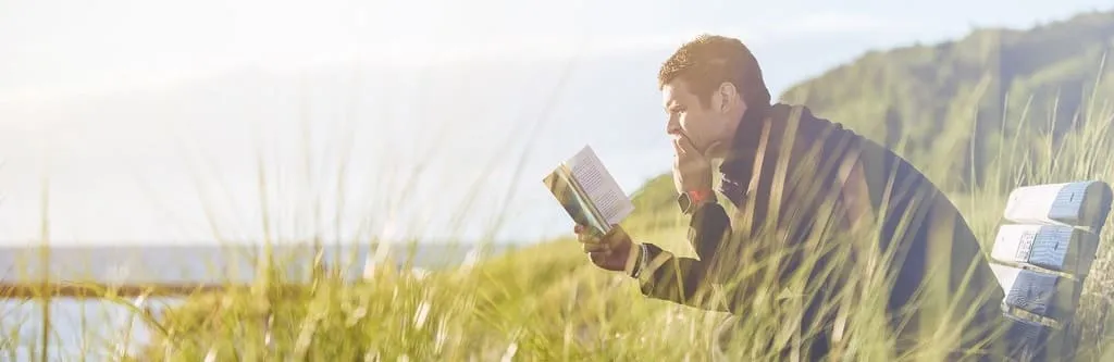 Glücklich sein ist einfach: Nehmen Sie ein fesselndes Buch, gehen in die Natur, setzen sich auf eine Bank und lesen.