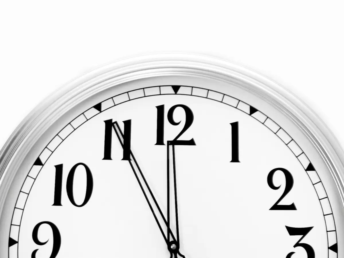 Nahaufnahme einer analogen Wanduhr, deren Zeiger kurz vor 12 Uhr stehen – metaphorisch für „fünf vor zwölf“