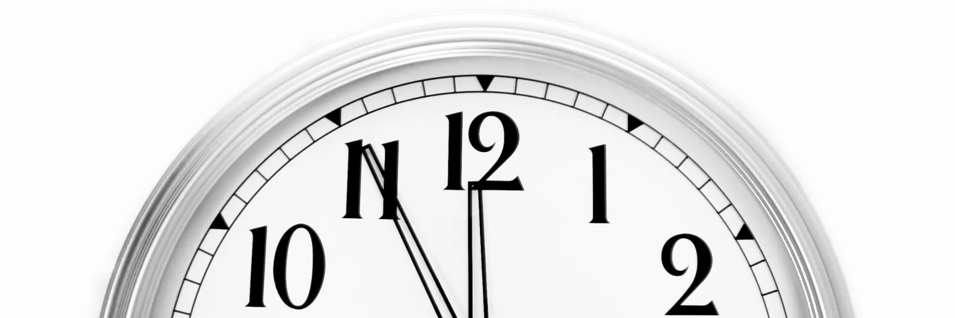 Nicht-Entscheidungen: Eine große, schlichte, silberne Uhr auf weißem Hintergrund, deren Minutenzeiger auf der Elf und deren Stundenzeiger auf der Zwölf stehen.