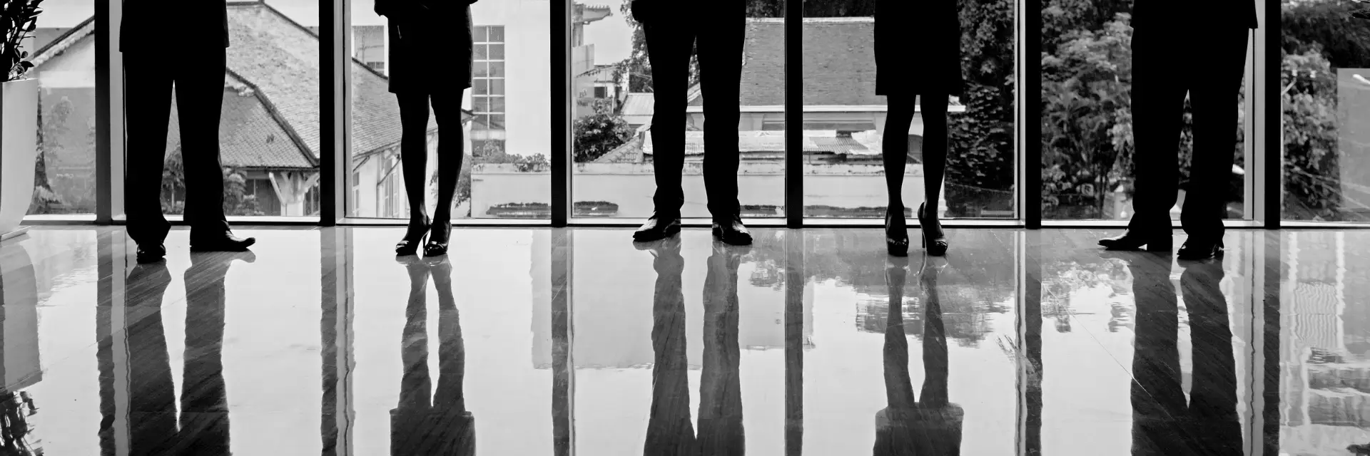 Komplexität: Mehrere Personen stehen nebeneinander in einem Raum ohne erkennbare Interaktion.