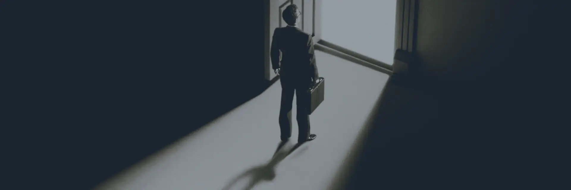 Unternehmer steht allein vor einer geöffneten Tür – Symbol für Entscheidung und echten Wandel im Change Management.
